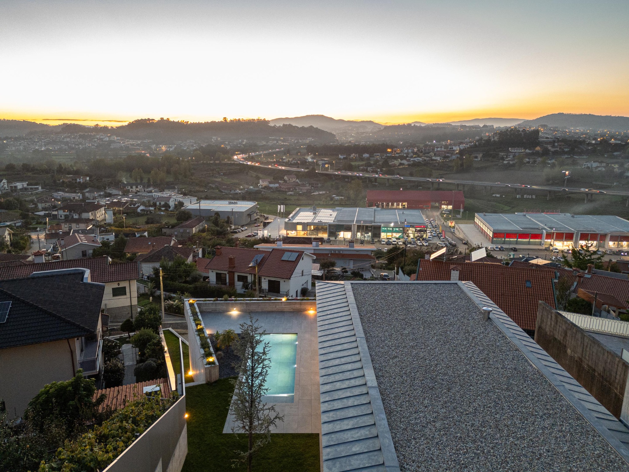 Casa A vista ao entardecer, com piscina, jardim e paisagem