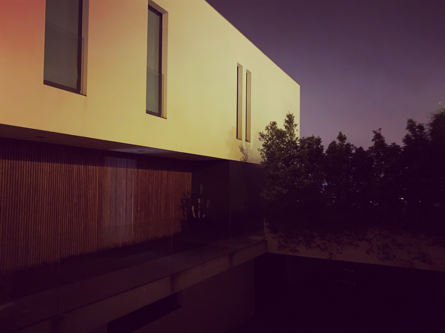 Fachada e jardim da Casa N ao anoitecer